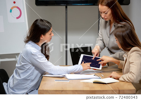 Young women talking, working with devices at office or living room 72480343