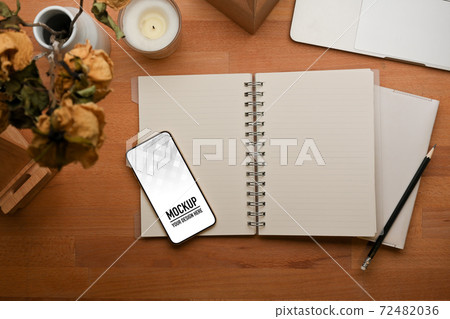 Opened blank notebook, smartphone and decorations on wooden table 72482036