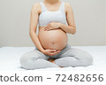 Pregnant woman touching her big belly. Close up. Motherhood, pregnancy, people and expectation concept. Pregnant woman expecting bab 72482656