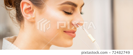 Woman receiving essential oil inhaler Woman receiving essential oil inhaler 72482749