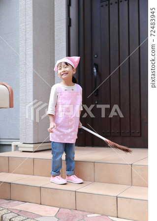 A 5-year-old girl helping to clean the front door 72483945