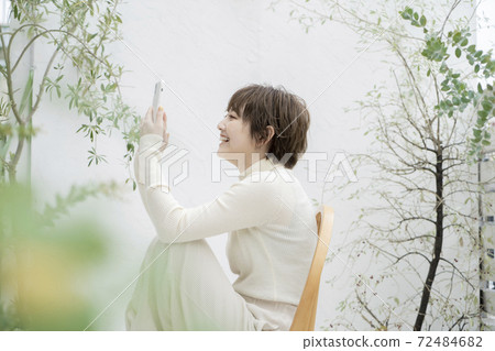 A young woman operating a smartphone 72484682