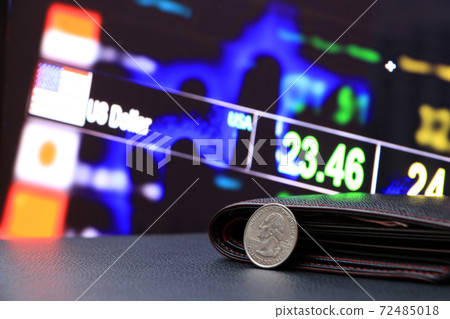 A quarter of US Dollar coins on obverse (USD) and black wallet on black floor with digital board 72485018