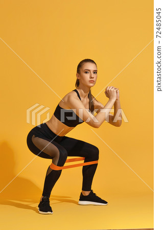 woman exercising with rubber resistance band woman exercising with rubber resistance band 72485045