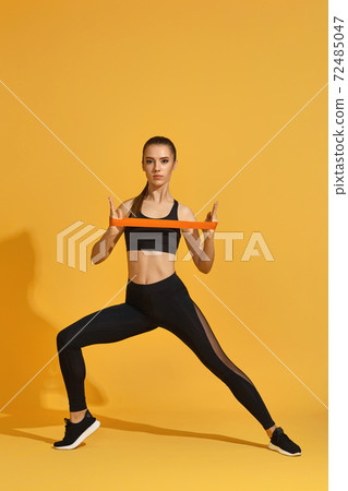 woman exercising with rubber resistance band woman exercising with rubber resistance band 72485047