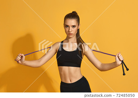 woman in black sportswear with jumping rope 72485050