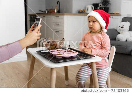 Mother taking photo of child at home. Modern motherhood 72485553