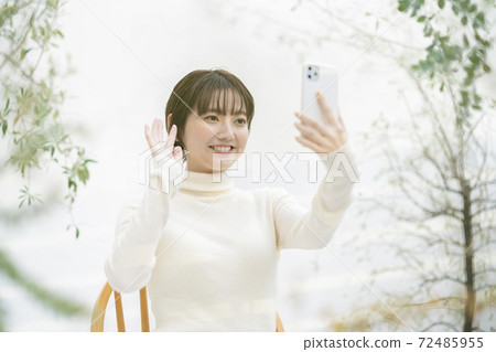 Woman making a video call using a smartphone Woman making a video call using a smartphone 72485955