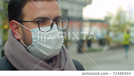 Covid-19 anti-epidemic concept. Body temperature measurement for coronavirus. A man's fever is measured to control the disease. Covid-19 anti-epidemic concept. Body temperature measurement for coronavirus. A man's fever is measured to control the disease. 72486434