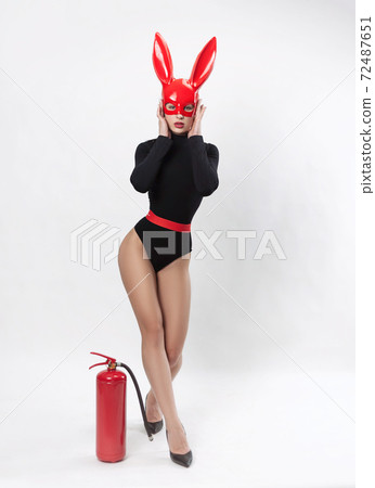 woman in red rabbit mask and black bodysuit on white background 72487651