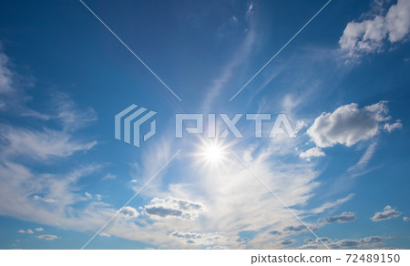 Blue sky with clouds and bright sun Blue sky with clouds and bright sun 72489150