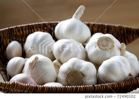 Garlic in a wooden bowl is ready to cook in the kitchen. Garlic in a wooden bowl is ready to cook in the kitchen. 72490102