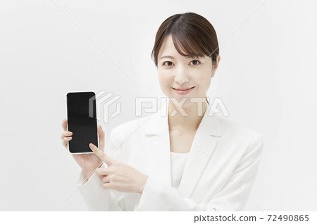 一個穿著白色西裝的女人拿著智能手機 72490865
