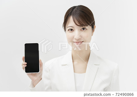 一個穿著白色西裝的女人拿著智能手機 72490866