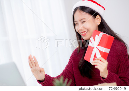 Young asian woman selfie video call online with friends and show red gift box in Christmas day. Young asian woman selfie video call online with friends and show red gift box in Christmas day. 72490949