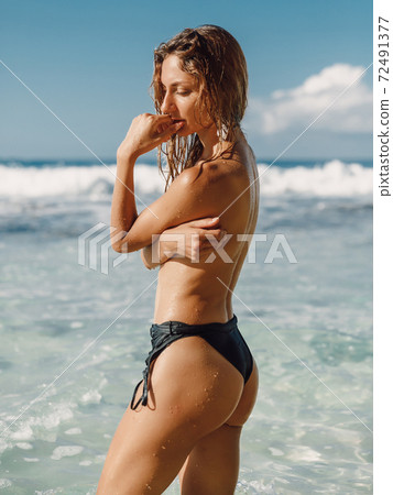 Naked woman at tropical ocean beach. Slim model with perfect body relax on beach 72491377