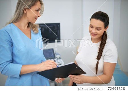 Skillful doctor providing examination for pregnant woman Skillful doctor providing examination for pregnant woman 72491828