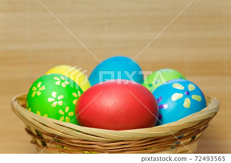 Colored  eggs in basket 72493565