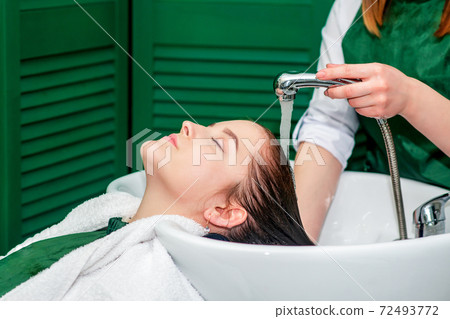 Hairdresser washes hair. Hairdresser washes hair. 72493772