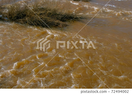 Streaming strong current on river at spring flood, high water. 72494002