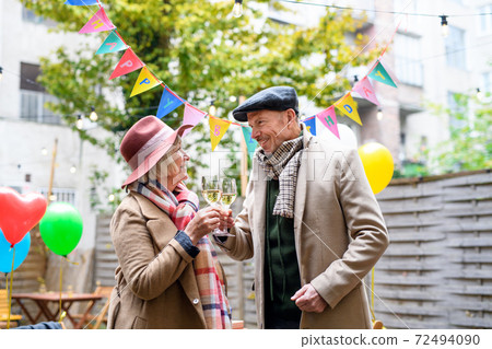 Happy senior couple with wine in outdoor cafe in city, celebrating birthday. Happy senior couple with wine in outdoor cafe in city, celebrating birthday. 72494090