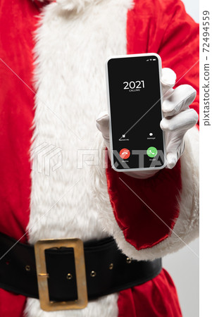 Close up hands of Santa Claus holding device with incoming call from 2021 year Close up hands of Santa Claus holding device with incoming call from 2021 year 72494559