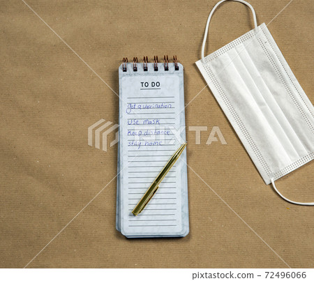 White medical masks and Notepad with measures against Coronavirus on brown paper background, COVID-19 concept modern design top view, copy space 72496066