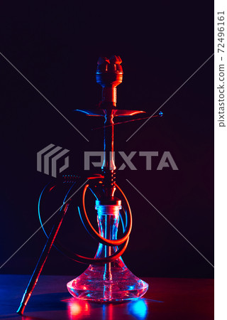 glass hookah with a metal bowl with hot coals on a black background on a table 72496161