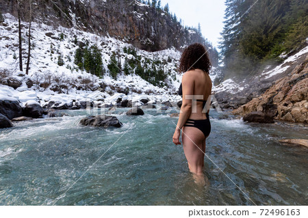 Caucasian Girl swimming in the Ice Cold Freezing Glacier River 72496163