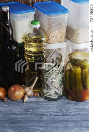 glass jar with paper dollars. against the background of products. Keeping the money. Investment. Financial crisis. Decline in the rate of growth of the dollar 72496899