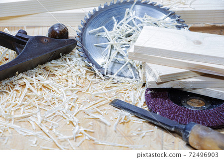 Carpenter tools on wooden table with sawdust. Circular Saw. Carpenter workplace top view. 72496903