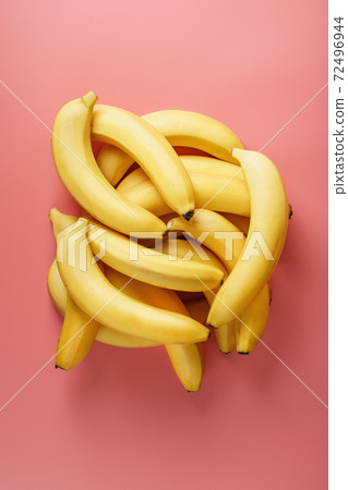 A bunch of ripe Yellow Bananas on a Pink Background. A bunch of ripe Yellow Bananas on a Pink Background. 72496944