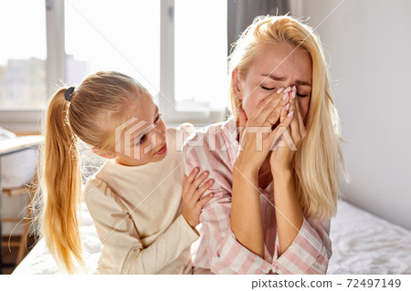 sympathetic kid girl calm down her crying mother 72497149
