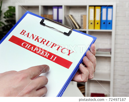 The banker reads the chapter 11 of the bankruptcy law. The banker reads the chapter 11 of the bankruptcy law. 72497187