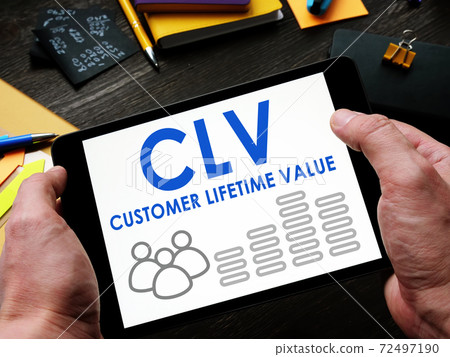 A man reads a Customer Lifetime Value CLV report on a tablet. A man reads a Customer Lifetime Value CLV report on a tablet. 72497190