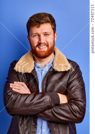open-minded caucasian guy in warm coat posing at camera open-minded caucasian guy in warm coat posing at camera 72497313