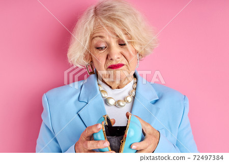 upset aged lady holding purse in hands upset aged lady holding purse in hands 72497384
