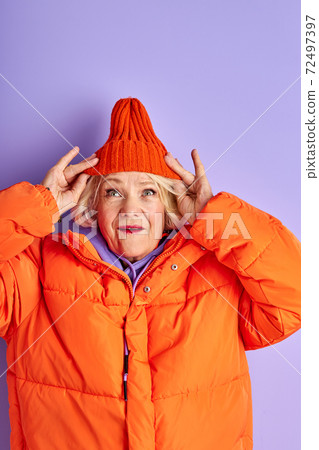 surprised emotional senior lady in orange clothes 72497397