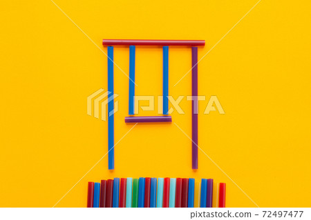 Children swing made of cocktail tubes, orange background 72497477
