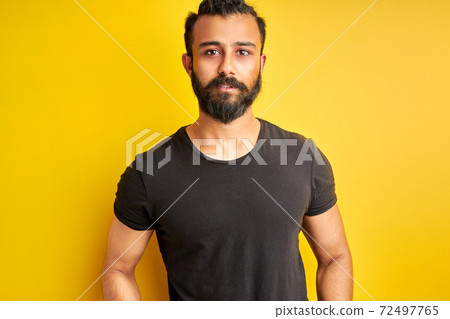 mysterious arabic male confidently looks at camera 72497765