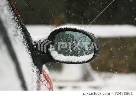 Car wing mirror covered up with fresh wet snow Car wing mirror covered up with fresh wet snow 72498861
