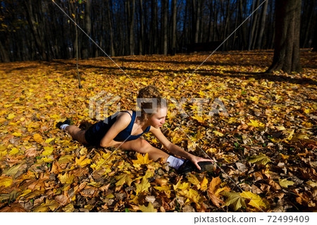 Healthy young woman warming up stretching her arms and looking away in the road outdoor. Healthy young woman warming up stretching her arms and looking away in the road outdoor. 72499409