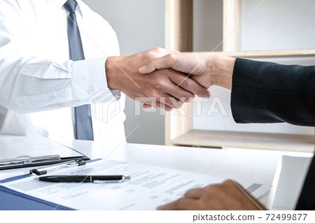 Greeting new colleagues, Handshake while job interviewing, male candidate shaking hands with Interviewer or employer after a job interview, employment and recruitment concept 72499877