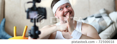 Cheerful man recording video during morning training Cheerful man recording video during morning training 72500018
