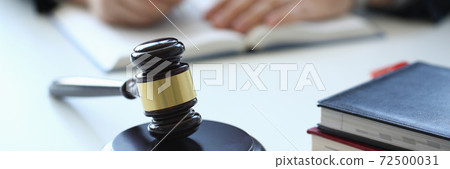 Young man sitting at the table with wooden handcrafted gavel 72500031