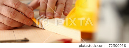 Male builder hands drawing line on sheet of paper 72500038