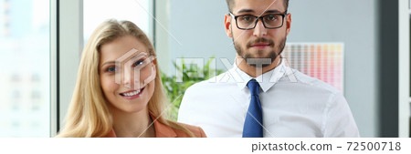 Joyful business colleagues standing in modern office Joyful business colleagues standing in modern office 72500718