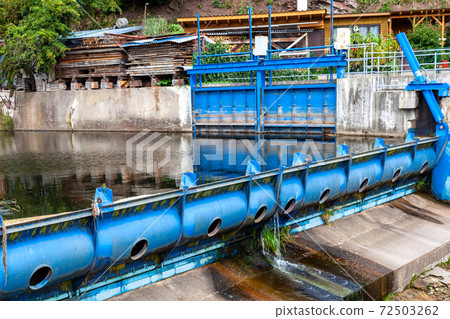 blue metal dam on a small river in the village 72503262