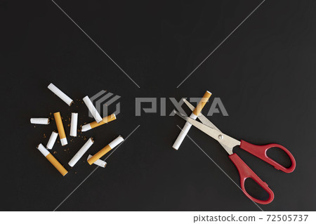 Overhead view broken cigarette with copy space and note , Stop smoking initiative concept of breaking cigarettes with workplace and pencil, Top view no smoke text with Scissor on black background, Wor 72505737