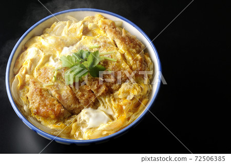A single shot of a hot katsudon in a bowl with a black background (overhead view) 72506385